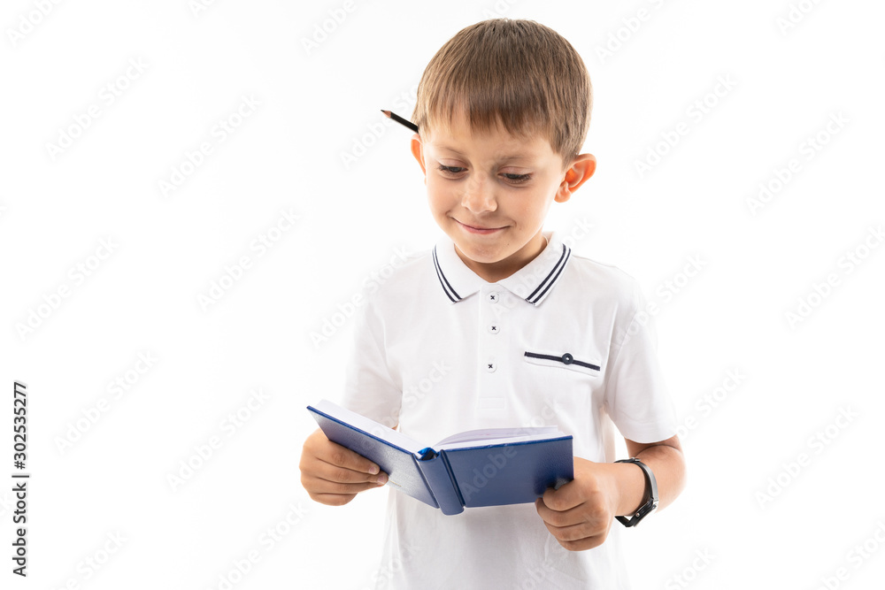 Portrait of a little caucasian boy in doubhts writting something in notebook and think Portrait of a little caucasian boy in doubhts writting something in notebook and think