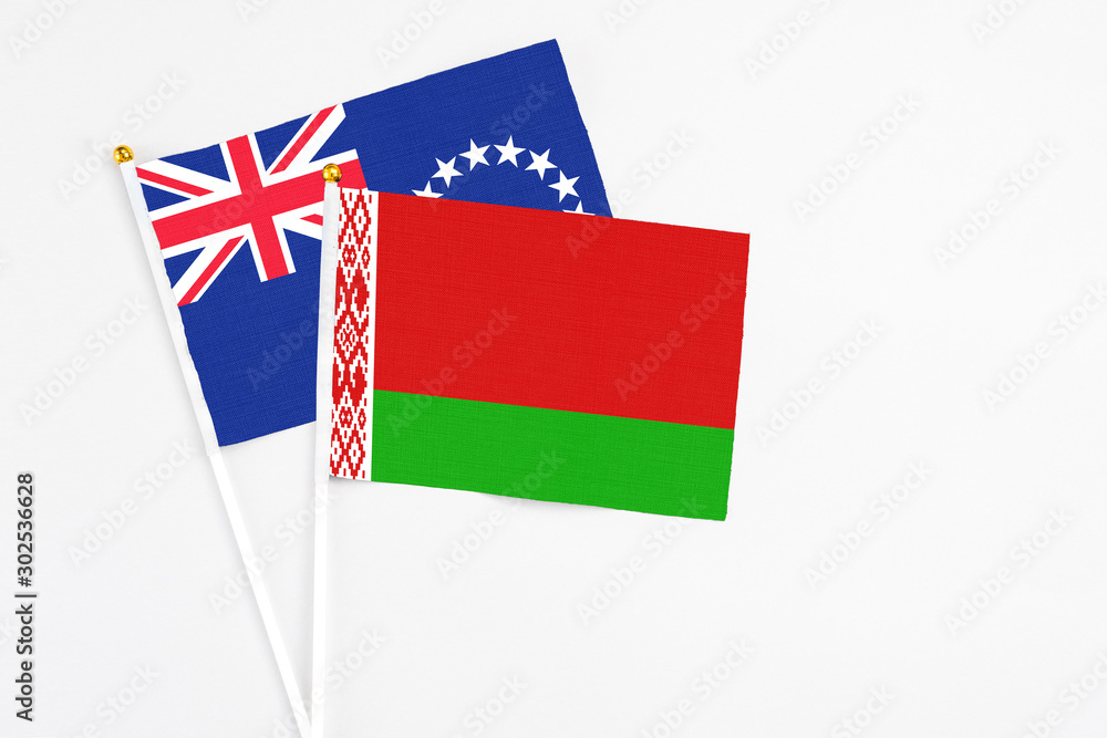 Belarus and Cook Islands stick flags on white background. High quality fabric, miniature national flag. Peaceful global concept.White floor for copy space.
