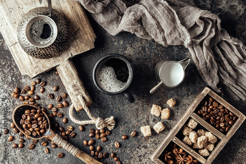 Coffee on wooden board with coffee beans on dark textured background. Top view with copy space. Background with free text space.