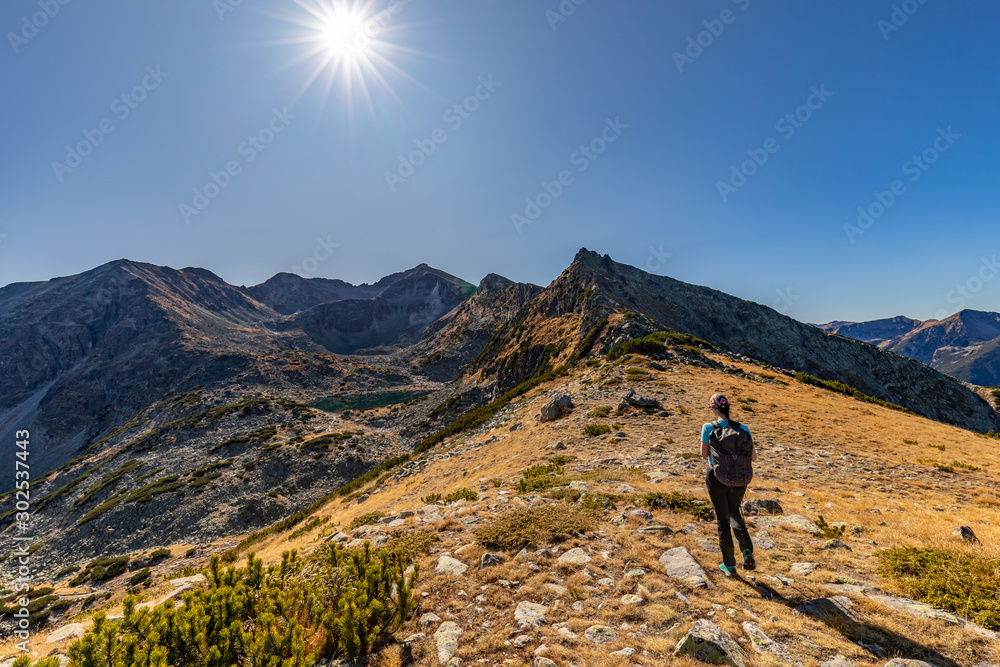 Woman hiking in Rila mountains on the way to Musala peak in Bulgaria on a sunny day in Autumn, Fall