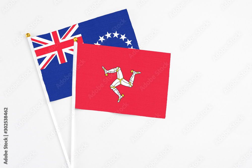 Isle Of Man and Cook Islands stick flags on white background. High quality fabric, miniature national flag. Peaceful global concept.White floor for copy space.