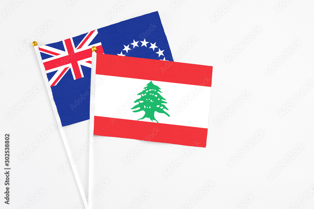 Lebanon and Cook Islands stick flags on white background. High quality fabric, miniature national flag. Peaceful global concept.White floor for copy space. Lebanon and Cook Islands stick flags on white background. High quality fabric, miniature national flag. Peaceful global concept.White floor for copy space.