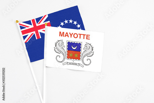Mayotte and Cook Islands stick flags on white background. High quality fabric, miniature national flag. Peaceful global concept.White floor for copy space.