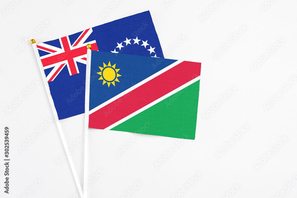 Namibia and Cook Islands stick flags on white background. High quality fabric, miniature national flag. Peaceful global concept.White floor for copy space. Namibia and Cook Islands stick flags on white background. High quality fabric, miniature national flag. Peaceful global concept.White floor for copy space.