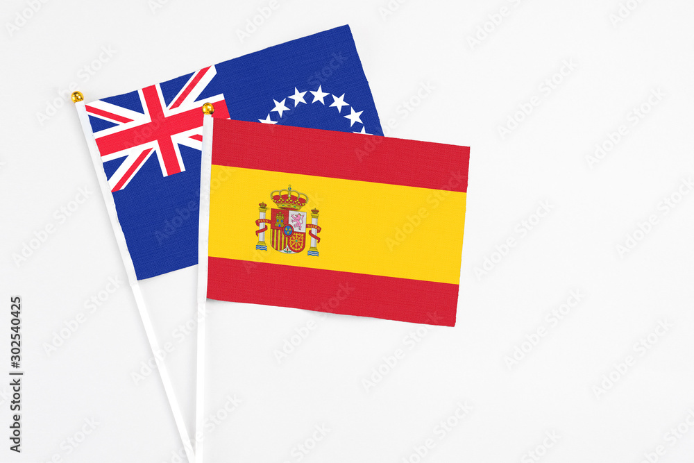 Spain and Cook Islands stick flags on white background. High quality fabric, miniature national flag. Peaceful global concept.White floor for copy space. Spain and Cook Islands stick flags on white background. High quality fabric, miniature national flag. Peaceful global concept.White floor for copy space.