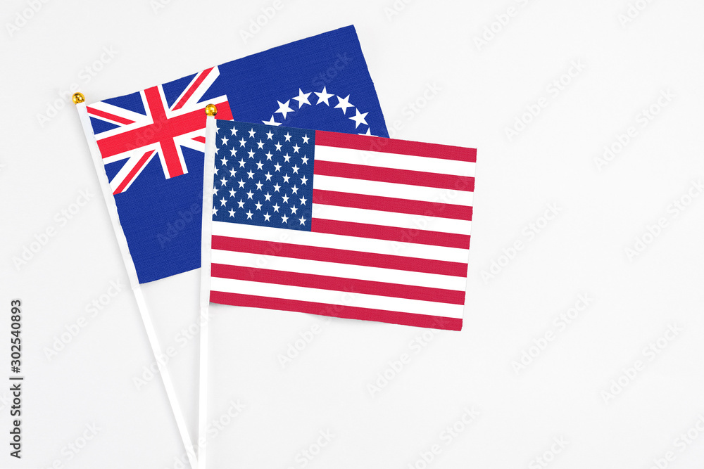 United States and Cook Islands stick flags on white background. High quality fabric, miniature national flag. Peaceful global concept.White floor for copy space. United States and Cook Islands stick flags on white background. High quality fabric, miniature national flag. Peaceful global concept.White floor for copy space.