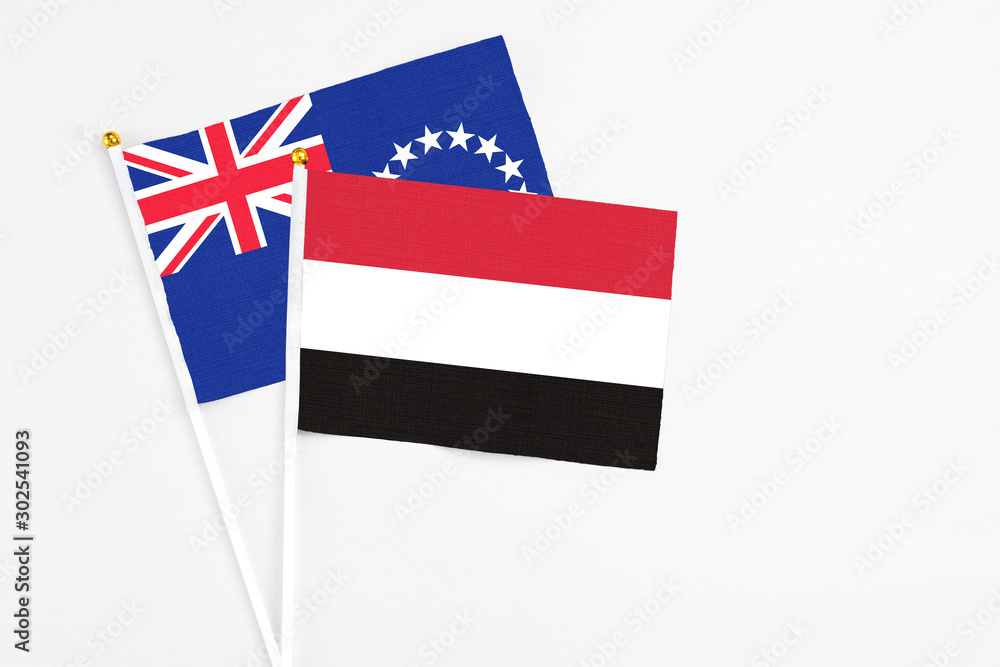 Yemen and Cook Islands stick flags on white background. High quality fabric, miniature national flag. Peaceful global concept.White floor for copy space. Yemen and Cook Islands stick flags on white background. High quality fabric, miniature national flag. Peaceful global concept.White floor for copy space.