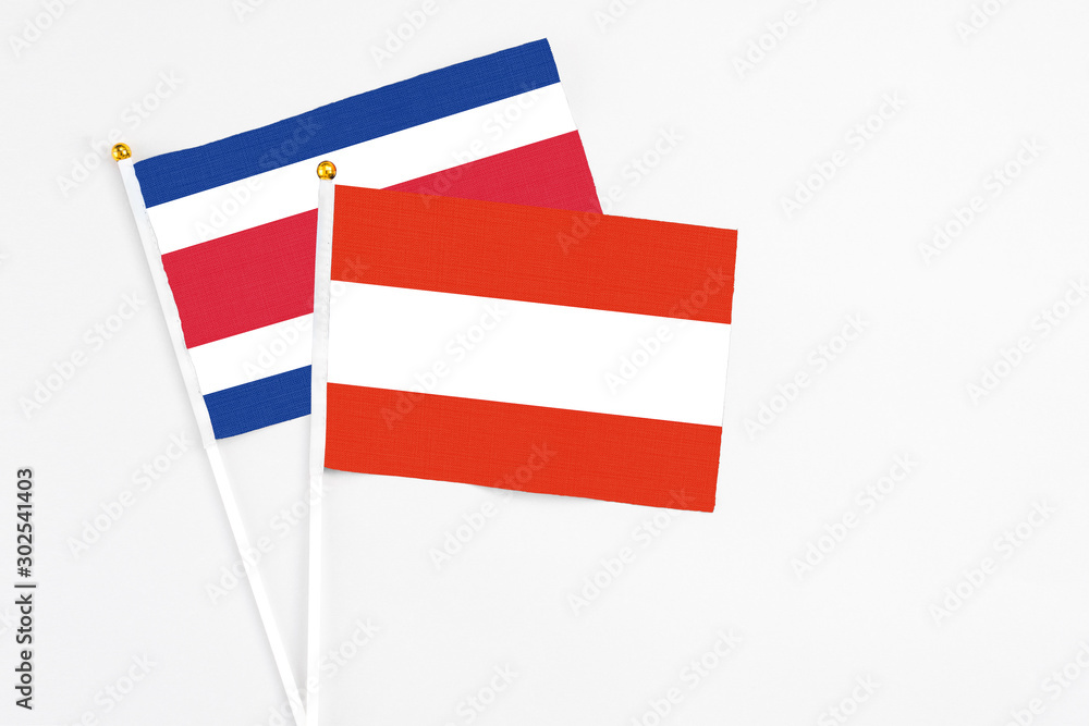 Austria and Costa Rica stick flags on white background. High quality fabric, miniature national flag. Peaceful global concept.White floor for copy space.