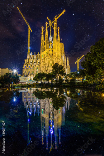 Photography Gaudis Sagrada familia with reflections in the middle of Barcelona´s night sky