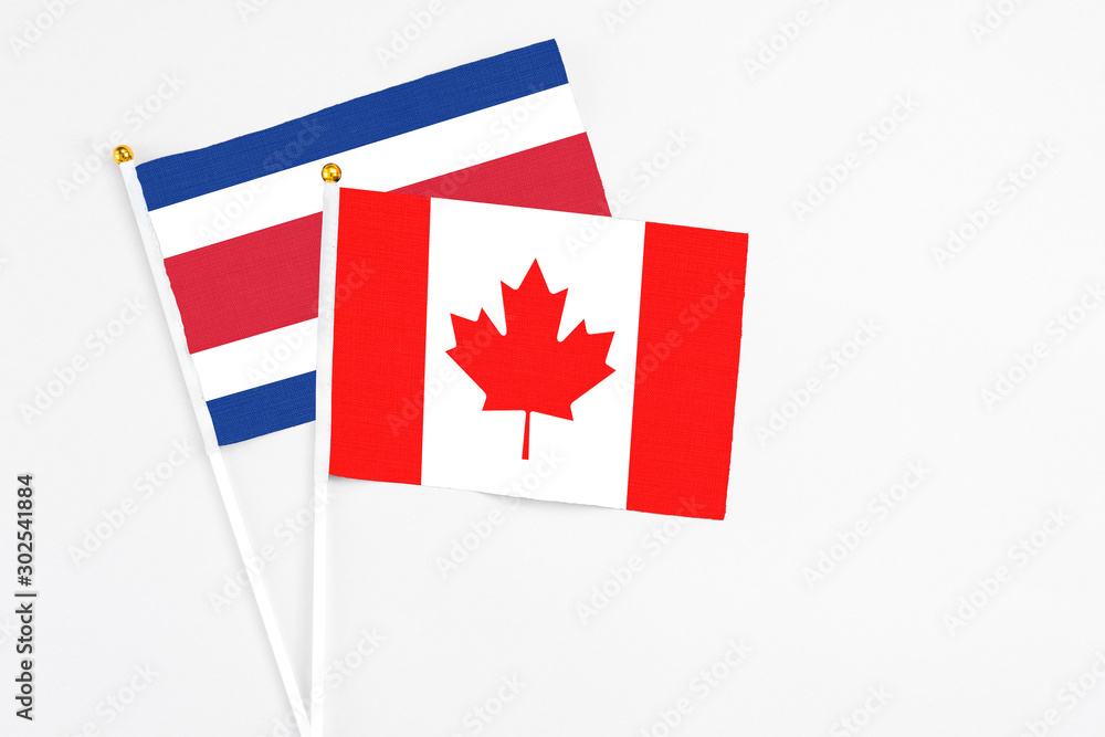 Canada and Costa Rica stick flags on white background. High quality fabric, miniature national flag. Peaceful global concept.White floor for copy space. Canada and Costa Rica stick flags on white background. High quality fabric, miniature national flag. Peaceful global concept.White floor for copy space.