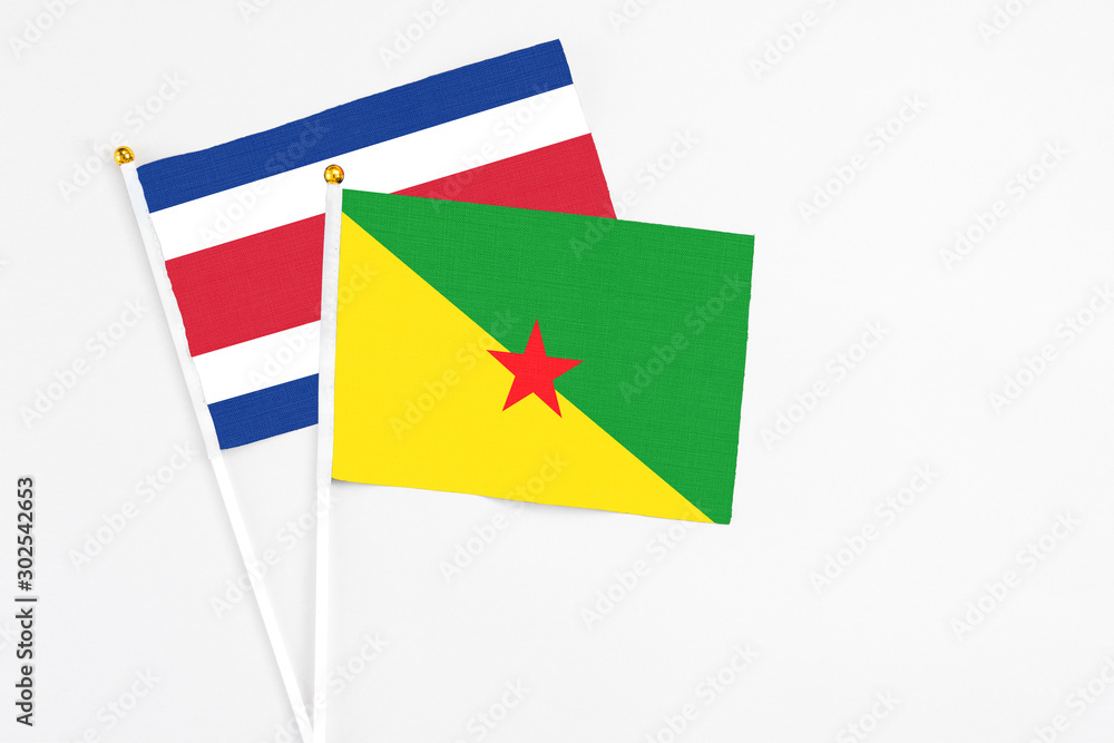 French Guiana and Costa Rica stick flags on white background. High quality fabric, miniature national flag. Peaceful global concept.White floor for copy space. French Guiana and Costa Rica stick flags on white background. High quality fabric, miniature national flag. Peaceful global concept.White floor for copy space.