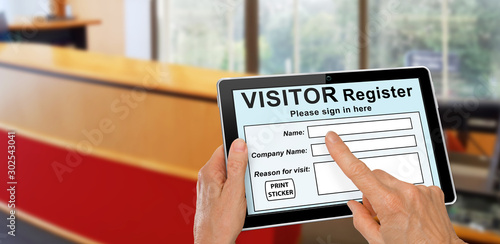 Obraz na płótnie Visitor completing a sign in register form on computer tablet