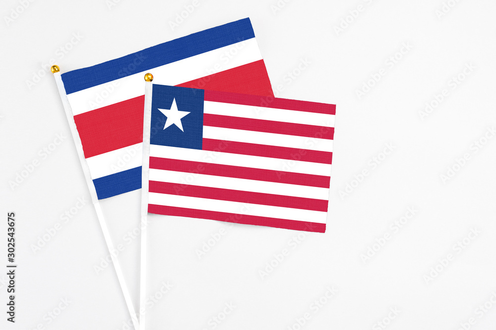 Liberia and Costa Rica stick flags on white background. High quality fabric, miniature national flag. Peaceful global concept.White floor for copy space. Liberia and Costa Rica stick flags on white background. High quality fabric, miniature national flag. Peaceful global concept.White floor for copy space.