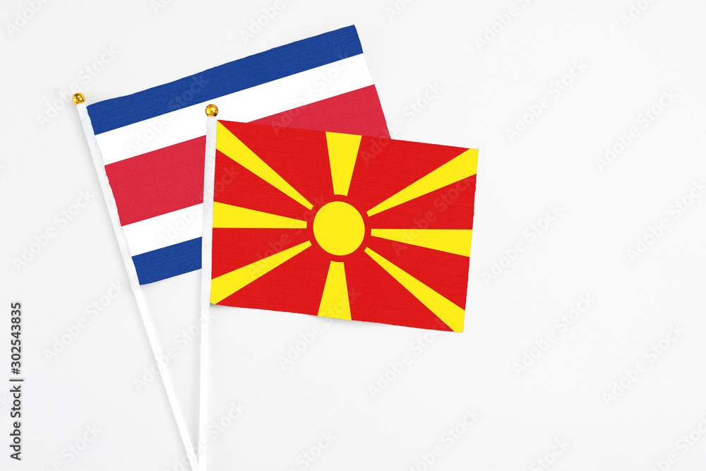 Macedonia and Costa Rica stick flags on white background. High quality fabric, miniature national flag. Peaceful global concept.White floor for copy space.