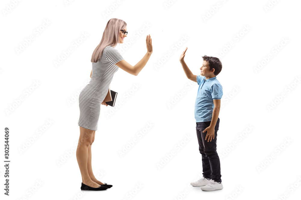 Young woman holding books and making a high-five gesture with a boy