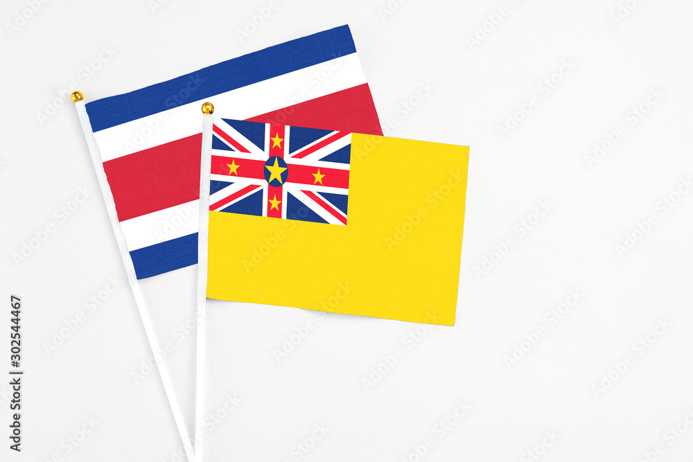 Niue and Costa Rica stick flags on white background. High quality fabric, miniature national flag. Peaceful global concept.White floor for copy space. Niue and Costa Rica stick flags on white background. High quality fabric, miniature national flag. Peaceful global concept.White floor for copy space.