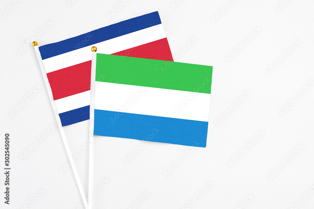 Sierra Leone and Costa Rica stick flags on white background. High quality fabric, miniature national flag. Peaceful global concept.White floor for copy space. Sierra Leone and Costa Rica stick flags on white background. High quality fabric, miniature national flag. Peaceful global concept.White floor for copy space.