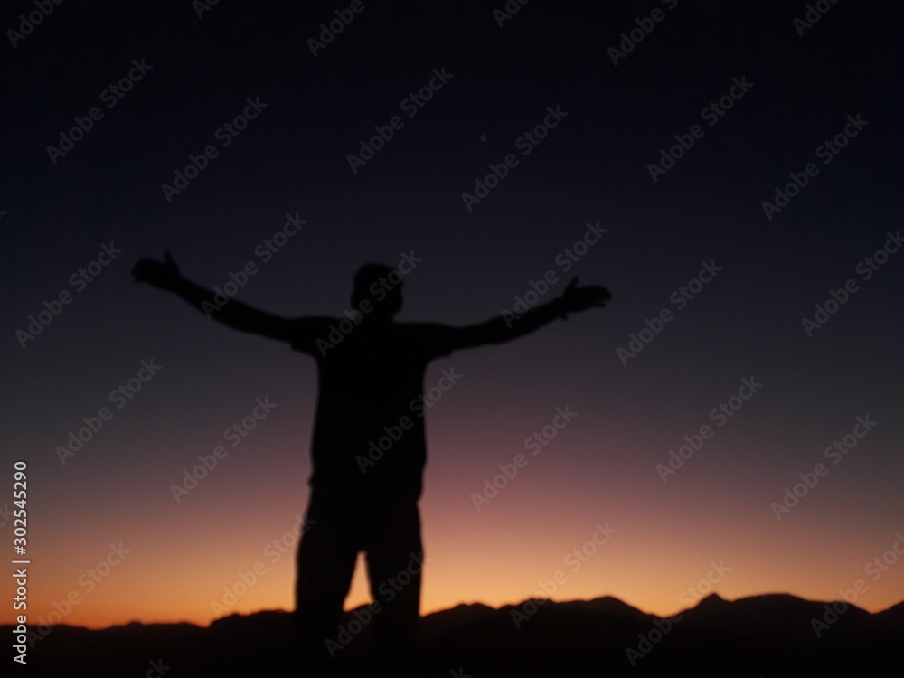 standing with arms wide open at sunset standing with arms wide open at sunset