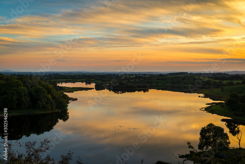 sunset with wellow sky, mirror reflection on the lake surface,  photo