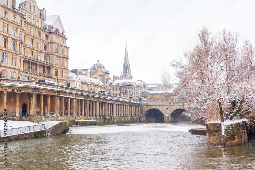Wintry view of Great Pulteney Bridge, Pulteney Weir and the River Avon on a  snowy day in January