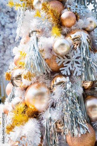 Christmas baubles hanging from the white Christmas tree at the entrance to The Emporium x The EmQuartier shopping mall in Bangkok, Thailand. photo