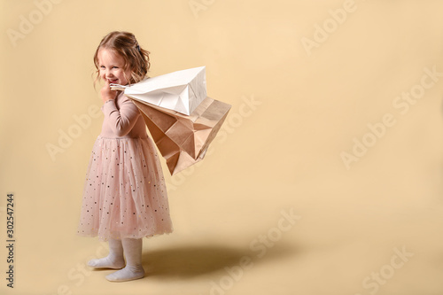 Small fashion girl . happy shopping girl runs with full bags and laughs. black Friday discount. cyber Monday. Present and gifts buy. summer sales. copy space.