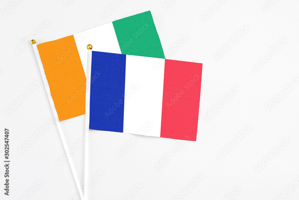 France and Cote D'Ivoire stick flags on white background. High quality fabric, miniature national flag. Peaceful global concept.White floor for copy space.
