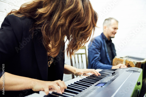 The girl plays the electronic piano at a concert.