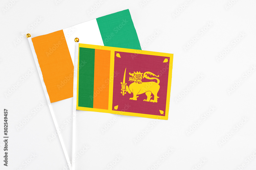 Sri Lanka and Cote D'Ivoire stick flags on white background. High quality fabric, miniature national flag. Peaceful global concept.White floor for copy space. Sri Lanka and Cote D'Ivoire stick flags on white background. High quality fabric, miniature national flag. Peaceful global concept.White floor for copy space.