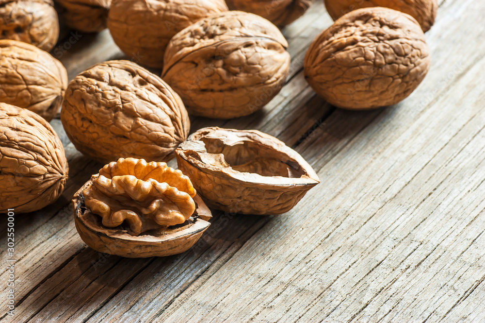 Ripe and raw whole big walnut kernel with thin shell on wooden rustic backdrop. healthy nut food for brain. Fresh walnuts background concept Ripe and raw whole big walnut kernel with thin shell on wooden rustic backdrop. healthy nut food for brain. Fresh walnuts background concept