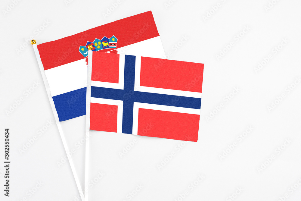 Bouvet Islands and Croatia stick flags on white background. High quality fabric, miniature national flag. Peaceful global concept.White floor for copy space.