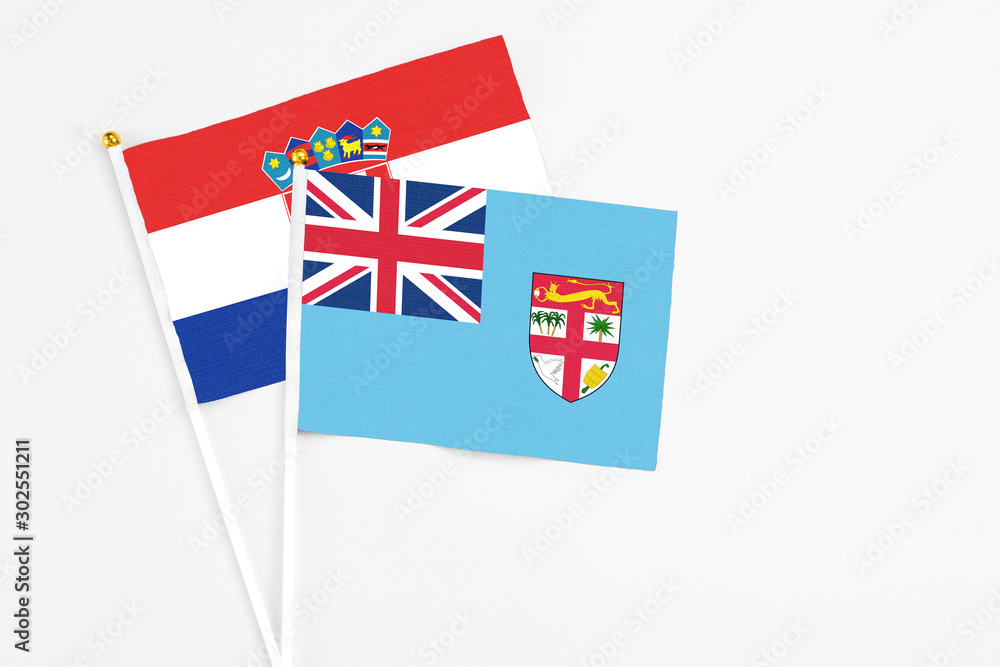 Fototapeta premium Fiji and Croatia stick flags on white background. High quality fabric, miniature national flag. Peaceful global concept.White floor for copy space.