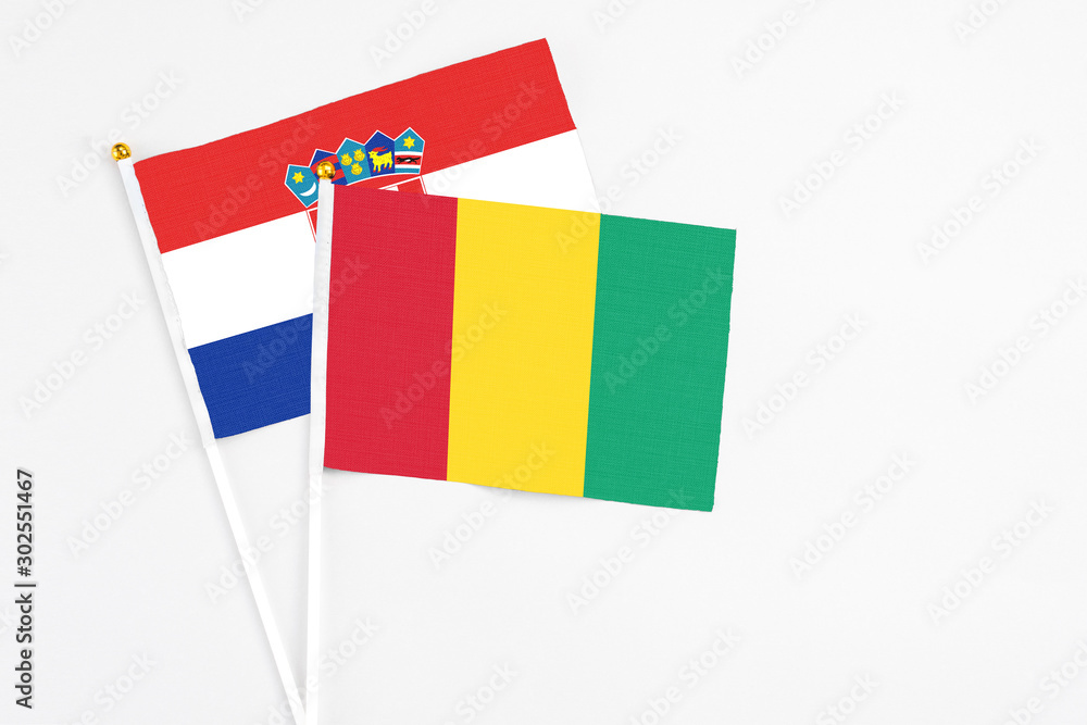 Guinea and Croatia stick flags on white background. High quality fabric, miniature national flag. Peaceful global concept.White floor for copy space. Guinea and Croatia stick flags on white background. High quality fabric, miniature national flag. Peaceful global concept.White floor for copy space.