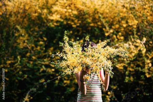 Kid holding flowers outdoors at spring