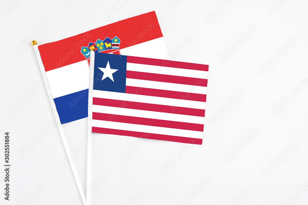 Liberia and Croatia stick flags on white background. High quality fabric, miniature national flag. Peaceful global concept.White floor for copy space. Liberia and Croatia stick flags on white background. High quality fabric, miniature national flag. Peaceful global concept.White floor for copy space.