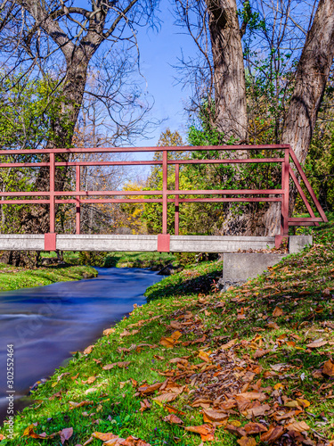 Fall view of a pedestrian bridge over a creek photo