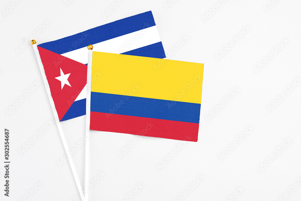 Colombia and Cuba stick flags on white background. High quality fabric, miniature national flag. Peaceful global concept.White floor for copy space. Colombia and Cuba stick flags on white background. High quality fabric, miniature national flag. Peaceful global concept.White floor for copy space.