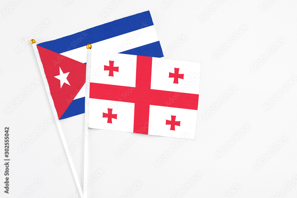 Georgia and Cuba stick flags on white background. High quality fabric, miniature national flag. Peaceful global concept.White floor for copy space.