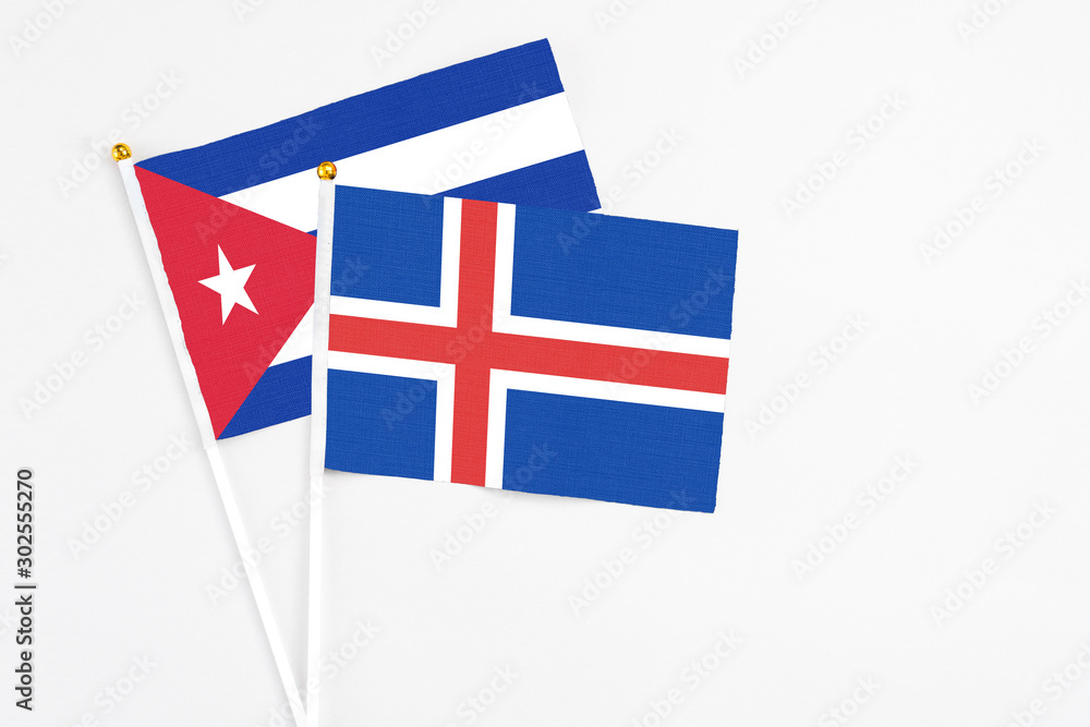 Iceland and Cuba stick flags on white background. High quality fabric, miniature national flag. Peaceful global concept.White floor for copy space.