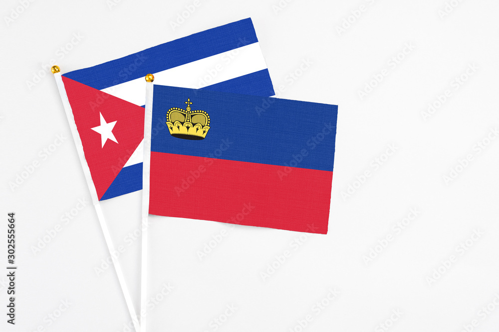 Liechtenstein and Cuba stick flags on white background. High quality fabric, miniature national flag. Peaceful global concept.White floor for copy space.