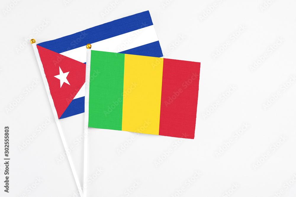 Mali and Cuba stick flags on white background. High quality fabric, miniature national flag. Peaceful global concept.White floor for copy space. Mali and Cuba stick flags on white background. High quality fabric, miniature national flag. Peaceful global concept.White floor for copy space.