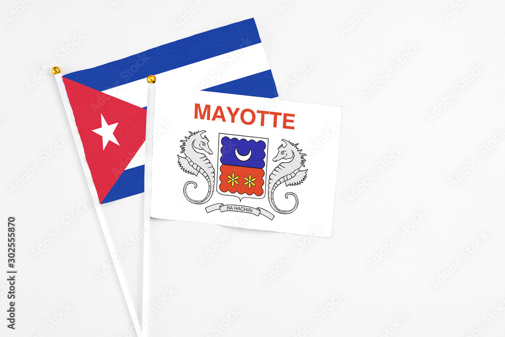 Mayotte and Cuba stick flags on white background. High quality fabric, miniature national flag. Peaceful global concept.White floor for copy space. Mayotte and Cuba stick flags on white background. High quality fabric, miniature national flag. Peaceful global concept.White floor for copy space.