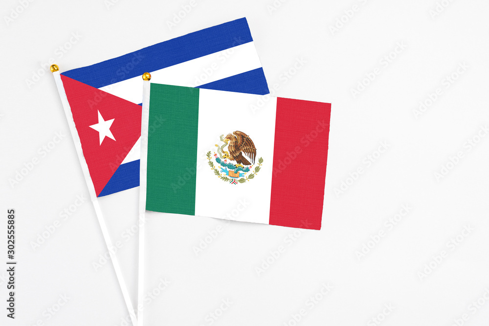 Mexico and Cuba stick flags on white background. High quality fabric, miniature national flag. Peaceful global concept.White floor for copy space.