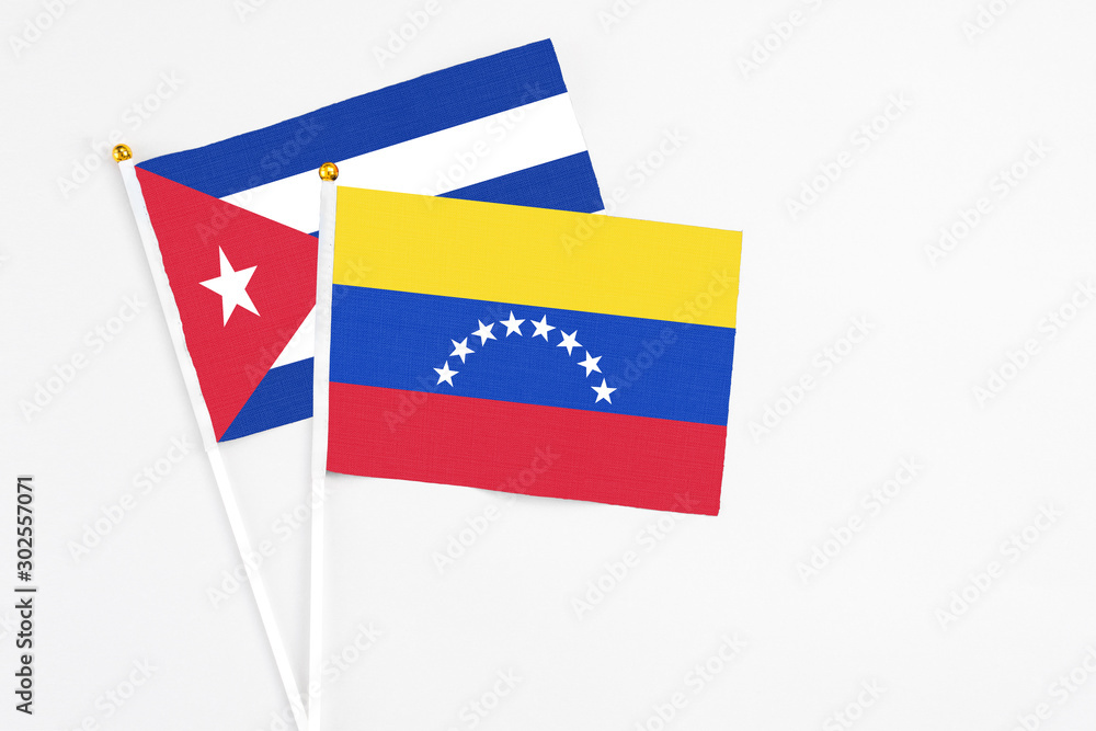 Venezuela and Cuba stick flags on white background. High quality fabric, miniature national flag. Peaceful global concept.White floor for copy space. Venezuela and Cuba stick flags on white background. High quality fabric, miniature national flag. Peaceful global concept.White floor for copy space.