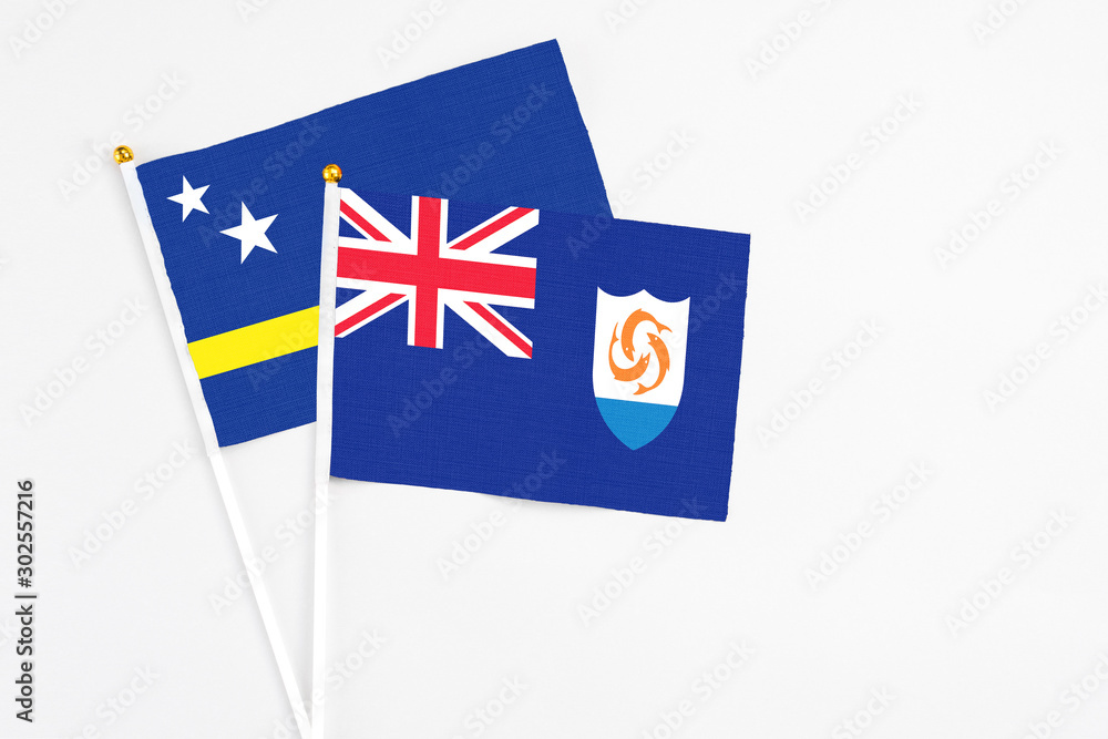 Anguilla and Curacao stick flags on white background. High quality fabric, miniature national flag. Peaceful global concept.White floor for copy space.