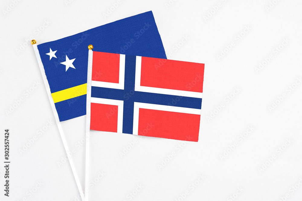 Bouvet Islands and Curacao stick flags on white background. High quality fabric, miniature national flag. Peaceful global concept.White floor for copy space.