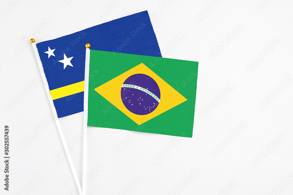 Brazil and Curacao stick flags on white background. High quality fabric, miniature national flag. Peaceful global concept.White floor for copy space.