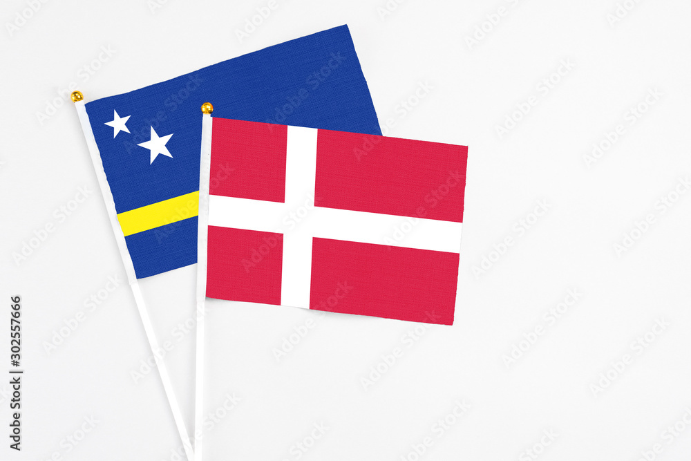 Denmark and Curacao stick flags on white background. High quality fabric, miniature national flag. Peaceful global concept.White floor for copy space.
