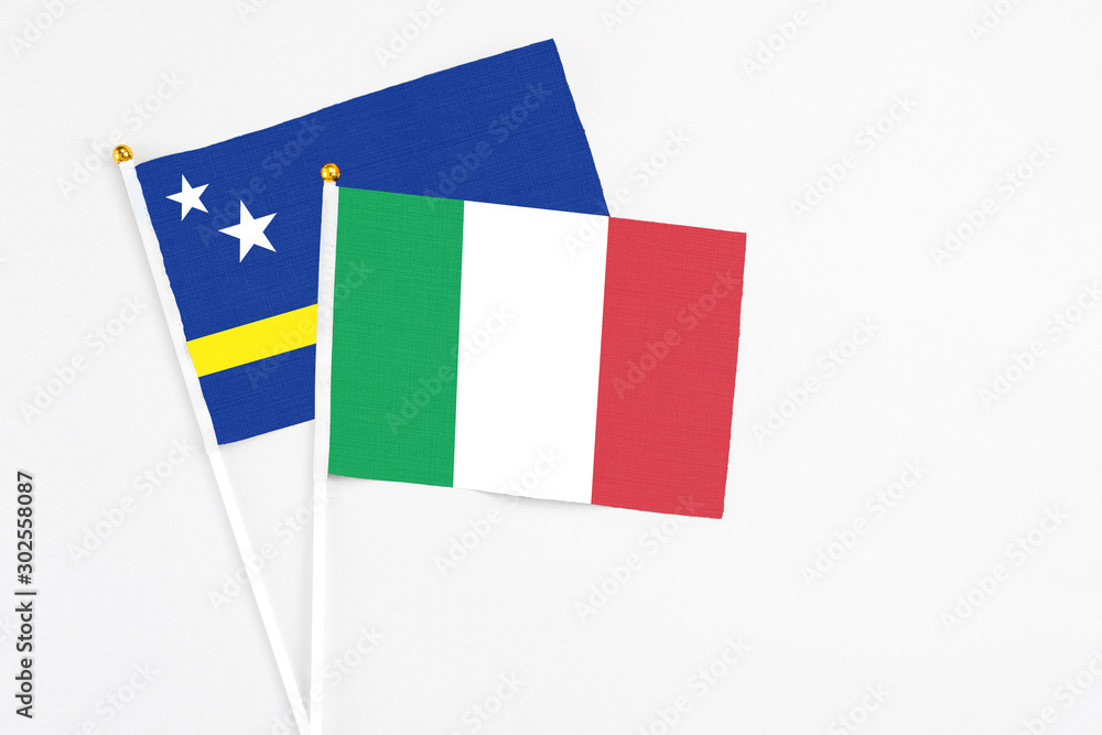 Italy and Curacao stick flags on white background. High quality fabric, miniature national flag. Peaceful global concept.White floor for copy space. Italy and Curacao stick flags on white background. High quality fabric, miniature national flag. Peaceful global concept.White floor for copy space.