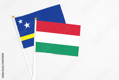 Hungary and Curacao stick flags on white background. High quality fabric  miniature national flag. Peaceful global concept.White floor for copy space.
